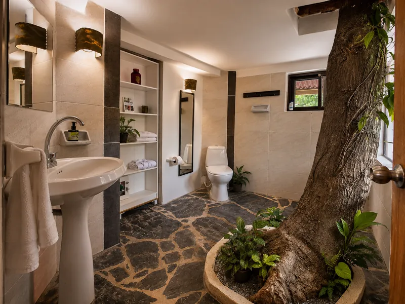 Baño con árbol de mango integrado, piso de piedra negra y lavabo